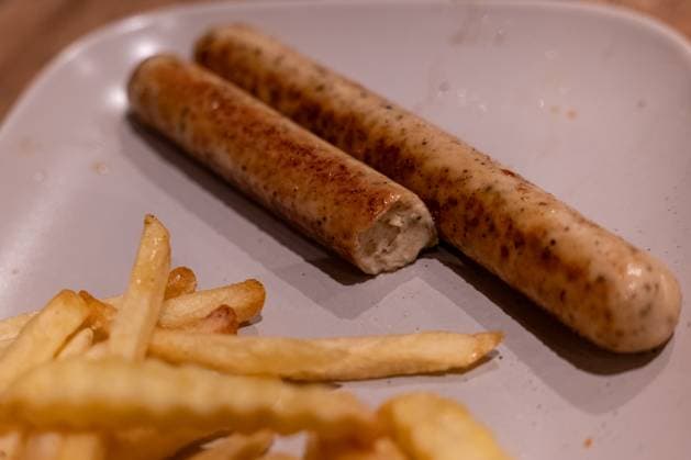 Vegane Bratwürste mit Pommes auf Teller 16.11.25, Selters: Symbolfoto, Illustrationsbild, Symbolbild, Illustrationsfoto, Alltagsszene Auf einem Teller liegen zwei gebratene vegane Bratwürste, von denen eine bereits angebissen ist. Im Vordergrund befinden sich Pommes frites. Das Foto zeigt eine servierte, einfache Mahlzeit mit pflanzlichem Fleischersatz und Beilage. Selters im Taunus Hessen Deutschland *** Vegan sausages with fries on plate 16 11 25, Selters Symbol photo, illustration picture, symbol image, illustration photo, everyday scene On a plate are two fried vegan sausages, one of which is already bitten into In the foreground are French fries The photo shows a served, simple meal with plant-based meat substitute and side dish S Copyright: xThorstenxWagnerx