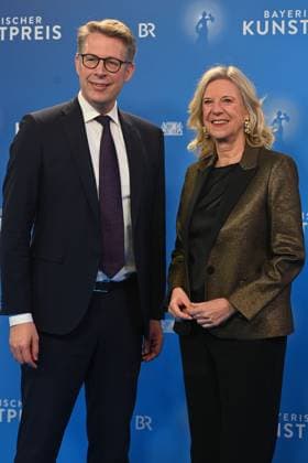 Markus BLUME (CSU,Bayerischer Staatsminister für Wissenschaft und Kunst) mit Katja WILDERMUTH (Intendantin Bayerischer Rundfunk BR). Verleihung Bayerischer Kunstpreis 2025 am 18.11.2025 im Bergson Kunstkraftwerk in Muenchen