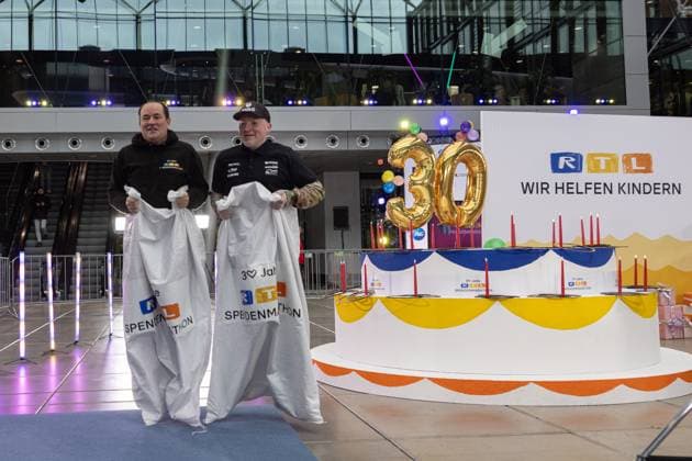 Pressetermin zum RTL Spendenmarathon in Köln, 19.11.2025. Wolfram KONS und Joey KELLY beim Sacküpfen (oder Hüpfsacken laut Kelly) - In der RTL-Zentrale in Köln-Deutz präsentieren Joey Kelly und Wolfram Kons die 24H GEBURTSTAGS-CHALLENGE zum 30. RTL-SPENDENMARATHON. Die 24-Stunden-Aktion mit 20 Firmenteams unterstützt die STIFTUNG RTL WIR HELFEN KINDERN E. V. und begleitet den Jubiläums-Spendenmarathon, der seit 1996 mehr als 306 Millionen Euro für Kinderhilfsprojekte gesammelt hat. Köln Deutz Nordrhein-Westfalen Deutschland Copyright: xBonn.digitalx