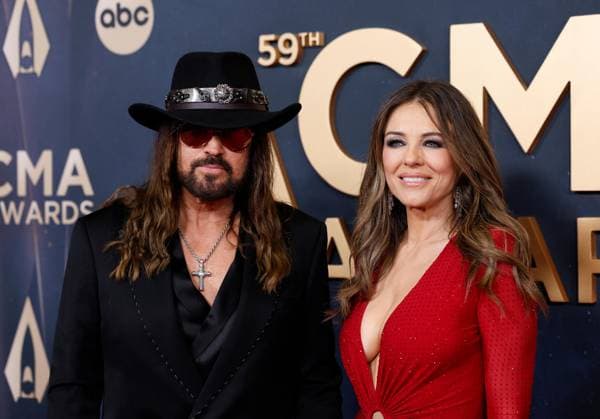 (L-R) Billy Ray Cyrus and Elizabeth Hurley arrive on the red carpet for the 59th CMA Awards in Nashville, Tennessee, on Wednesday, November 19, 2025.  NAS20251119240 JOHNxANGELILLO
