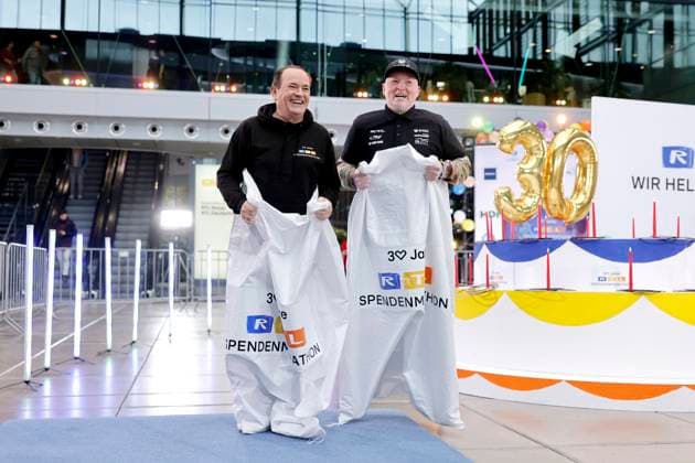 Moderator Wolfram Kons und Sänger Joey Kelly beim Sackhüpfen bei einem Fototermin zu 30 Jahre RTL-Spendenmarathon im RTL-Gebäude am Picassoplatz. Köln, 19.11.2025 NRW Deutschland Copyright: xChristophxHardtx