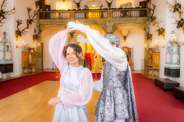 Winterausstellung auf Schloss Moritzburg, Mit Aschenbrödel zum Ball. Die Aschenbrödel-Saison startet im Schloss Moritzburg. Vom 21. November 2025 bis 1. März 2026 sind im Schloss wieder Originalkostüme, nachgebildete Filmszenen und Requisiten ausgestellt. Am authentischen Drehort wird der Märchenfilm Drei Haselnüsse für Aschenbrödel lebendig. Mit dem Motto Auf zum Ball! setzen die Ausstellungsmacher in der 14. Winterausstellung einen besonderen Akzent. Der barocke Speisesaal mit der imposanten Geweihsammlung wird erstmals komplett für Gäste begehbar. Gäste können in eigenen Kostümen, den beliebten Besucherkostümen oder natürlich in Zivil Walzer tanzen. Zum Pressetermin tanzten Anna Gregor und Felix Hauke. Moritzburg Sachsen