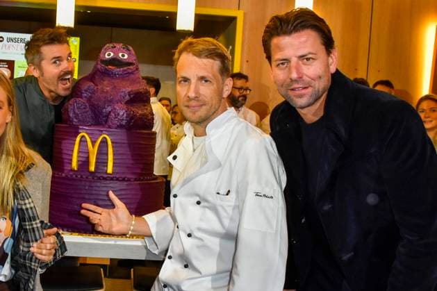 ABB Thore Schoelermann Oliver Pocher mit Lilla eroeffnungs Torte Roman Weidenfeller der Moderator und Schauspieler traegt eine weisse Koch Jacke bei der Wiedereroeffnung der MC Donald Filiale Schnell Restaurant in Essen am 23.11.2025 NRW Deutschland