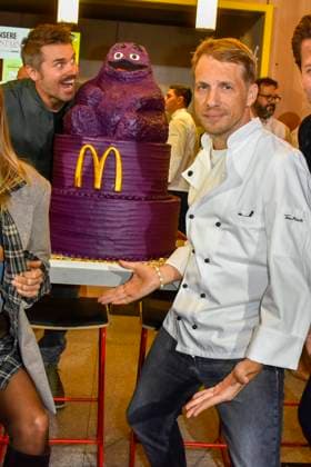 ABB Thore Schoelermann Oliver Pocher mit Lilla eroeffnungs Torte der Moderator und Schauspieler traegt eine weisse Koch Jacke bei der Wiedereroeffnung der MC Donald Filiale Schnell Restaurant in Essen am 23.11.2025 NRW Deutschland