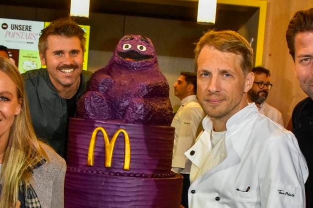 ABB Thore Schoelermann Oliver Pocher mit Lilla eroeffnungs Torte der Moderator und Schauspieler traegt eine weisse Koch Jacke bei der Wiedereroeffnung der MC Donald Filiale Schnell Restaurant in Essen am 23.11.2025 NRW Deutschland