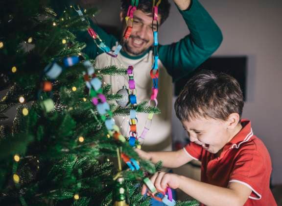 Father and child joyfully decorating Christmas tree indoors model released, Symbolfoto property released, ANAF05313