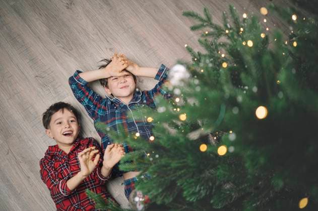Children in pajamas smiling and playing near Christmas tree indoors model released, Symbolfoto property released, ANAF05323