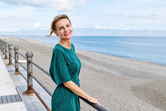 Smiling businesswoman in green dress by the beach looking at camera model released, Symbolfoto, CATF00837