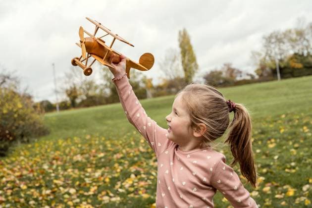 Kid playing with wooden airplane outdoors in autumn park model released, Symbolfoto, IGEF00336