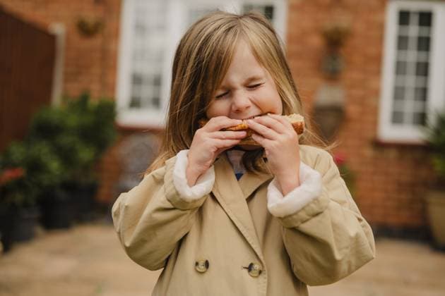 Child eating sourdough bread outdoors in a garden model released, Symbolfoto property released, IGEF00364