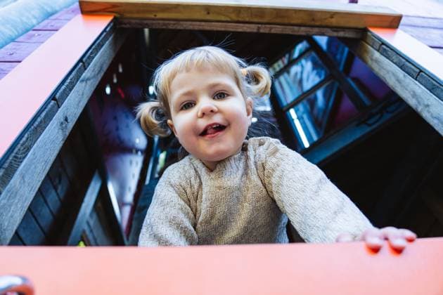 Smiling child playing at outdoor playground looking down from window model released, Symbolfoto, IHF02540