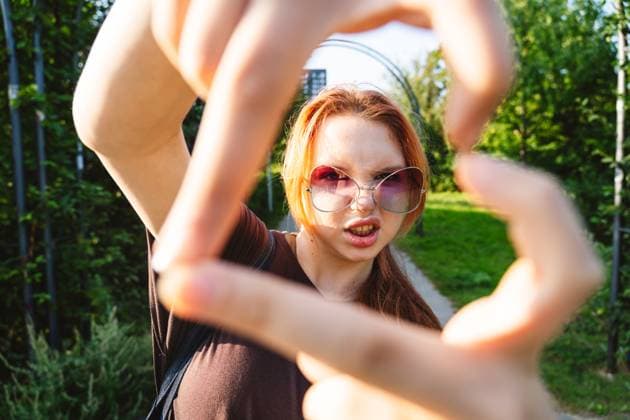 Teen using heart gesture with rebellious attitude and bold expression outdoors model released, Symbolfoto, IHF02554