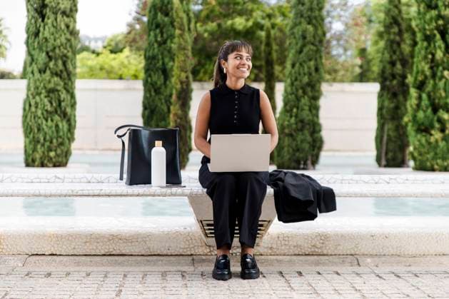 Businesswoman working on laptop in urban park with neo-futurist style model released, Symbolfoto, PCLF02961