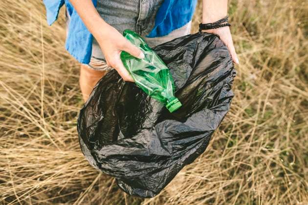 Woman collecting trash in grass for environmental protection outdoors model released, Symbolfoto, SIF01469