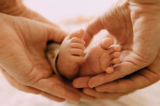 Parent hands gently holding newborn baby feet showing family love model released, Symbolfoto property released, VIVF01723