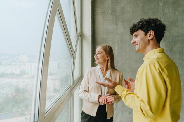 Businesswoman and businessman discussing in office by window model released, Symbolfoto property released, YTF04256