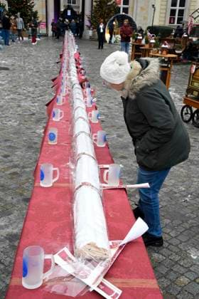 ABB Besucher am Stollen beim Charity Verkauf von probier Stuecken des laengsten Berliner Christstollen von der Familien Baeckerei Roesler zu gunsten der Organisation Augenlicht auf dem Wintermarkt im Berliner Forum am 24,11.2025 in Berlin Berlin Deutschland