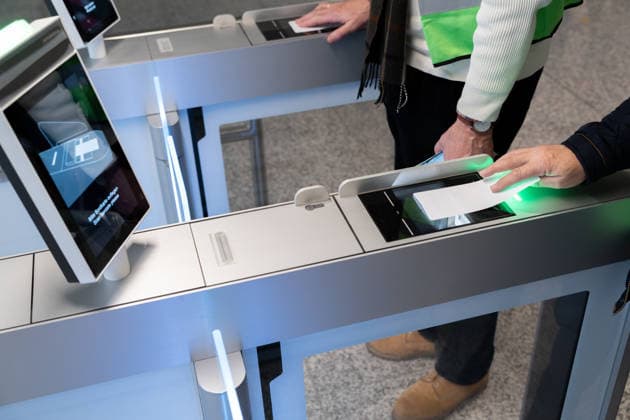 Munich, Bavaria, Germany - November 25, 2025: Trial operation for the new boarding gate in Terminal 1 at Munich Airport. Volunteers test processes ahead of the planned opening in 2026. Travelers hold their printed boarding passes ready for electronic scanning at the self-boarding gate *** Probebetrieb für den neuen Flugsteig im Terminal 1 des Flughafens München. Freiwillige testen Abläufe vor der geplanten Eröffnung 2026. Reisende halten ihre gedruckten Bordkarten am Self-Boarding-Gate zum elektronischen Scan bereit