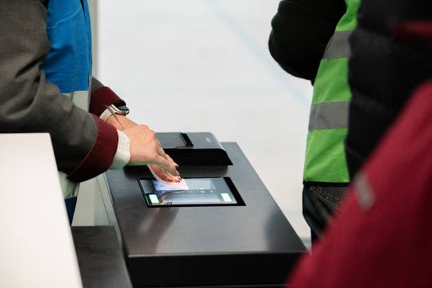Munich, Bavaria, Germany - November 25, 2025: An employee scans a boarding pass at the counter at Munich Airport while ground staff prepare for the boarding process. Trial operation for the new boarding gate in Terminal 1 at Munich Airport. Volunteers test processes ahead of the planned opening in 2026 *** Eine Mitarbeiterin scannt am Schalter im Flughafen München eine Bordkarte, während Bodenpersonal den Boarding-Vorgang vorbereitet. Probebetrieb für den neuen Flugsteig im Terminal 1 des Flughafens München. Freiwillige testen Abläufe vor der geplanten Eröffnung 2026