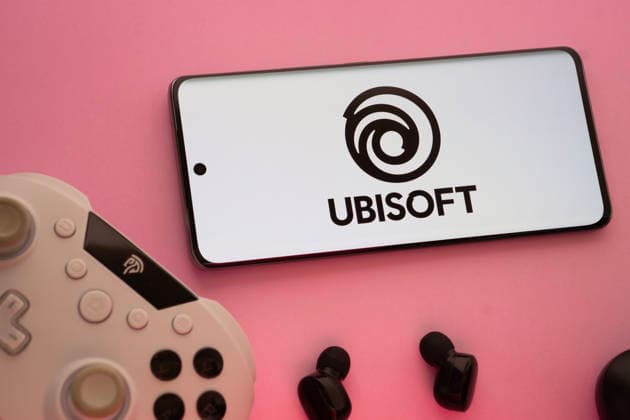 Dhaka, Bangladesch - 22. März 2025: Smartphone mit Ubisoft-Logo, Game-Controller und Ohrstöpsel auf einem rosa Hintergrund. Dhaka, Bangladesh- 22 Mar 2025: Smartphone with Ubisoft logo, game controller, and earbuds on a pink background. (License=RM) Copyright: xZoonar.com MojahidxMottakinx 24272811