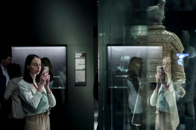 (251128) -- BUDAPEST, Nov. 28, 2025 -- A visitor takes photos of exhibits at the exhibition Civilization of the Qin and Han Dynasties - The First Chinese Emperor s Terracotta Warriors at the Museum of Fine Arts in Budapest, Hungary, Nov. 27, 2025. The Museum of Fine Arts in Budapest on Thursday opened one of the most significant Chinese cultural exhibitions ever held in Hungary, presenting more than 150 ancient artworks from the Qin and Han dynasties (221 BC-220 AD), including ten original Terracotta Warriors. Titled Civilization of the Qin and Han Dynasties - The First Chinese Emperor s Terracotta Warriors, the exhibition is jointly organized by the Museum of Fine Arts in Budapest and the Shaanxi Provincial Cultural Heritage Admini 