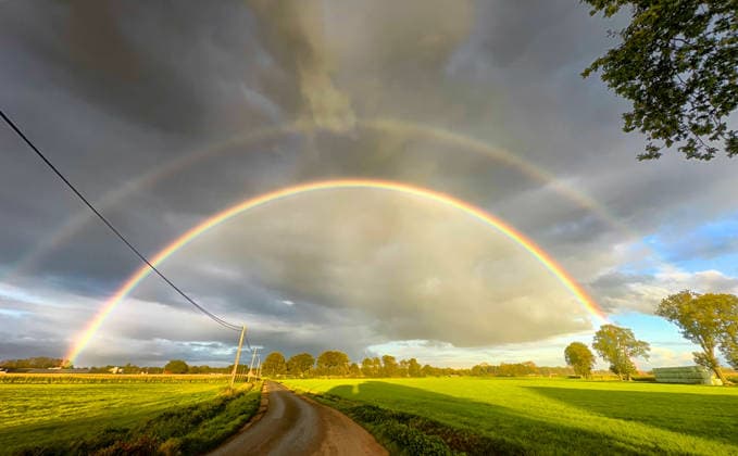 Erleben Sie die atemberaubende Schönheit eines doppelten Regenbogens, der sich über üppige, grüne Felder wölbt A breathtaking view of a stunning double rainbow gracefully arching over vibrant green fields beneath dramatic skies (License=RF) Copyright: xZoonar.com BjornxBeheydtx 24282190