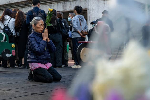 News Bilder des Tages Hong Kong Building Fire A woman kneeling on the ground near the scene where a major fire engulfed several residential buildings at Wang Fuk Court on November 29, 2025 in Hong Kong. (Photo by Vernon Yuen Nexpher Images) Hong Kong