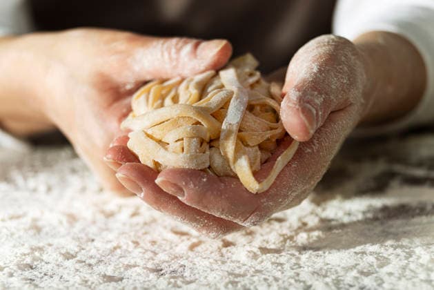 Kaukasische weibliche Hände halten rohe Fettuccine-Nudeln nach dem Trocknen Caucasian female hands holding raw fettuccine noodles after drying (License=RF) Copyright: xZoonar.com OlenaxMykhaylovax 24288542