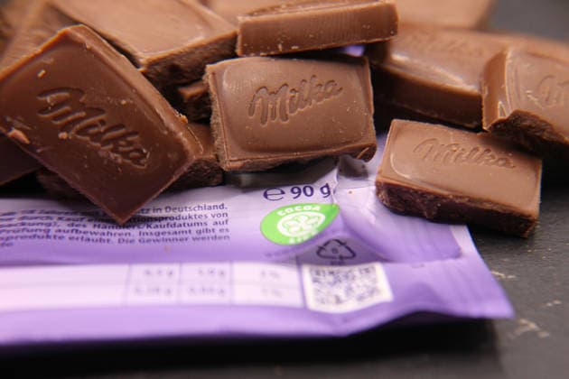 Stückchen einer Schokoladentafel der Marke Milka Alpenmilch liegen auf einer Schieferplatte. Schnelsen Hamburg *** Pieces of a Milka Alpenmilch chocolate bar lying on a slate Schnelsen Hamburg
