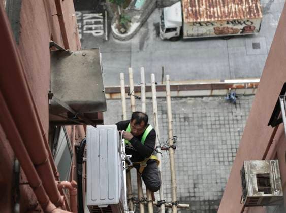 December 2, 2025, Hong Kong, China: In Hong Kong, a worker fixing air conditioner on the outer wall of a building working on the traditional bamboo scaffoldings. Fierce controversy have aroused in Hong Kong since catastrophic fire hit Hong Kong last Wednesday which devastated public housing estate. Meanwhile referring to the cause of fire, government is putting the blame on the traditional bamboo materials used for scaffoldings. This view of the government have quickly denied by many professionals in the scaffolding industries as well as ordinary citizens claiming bamboo are fine natural fire-retardant material in comparison to the steel pipes which, government is now promoting to replace it by discarding the use of bamboos in the future.De - ZUMAl137 20251202_fap_l137_001 Copyright: xLiauxChung-renx