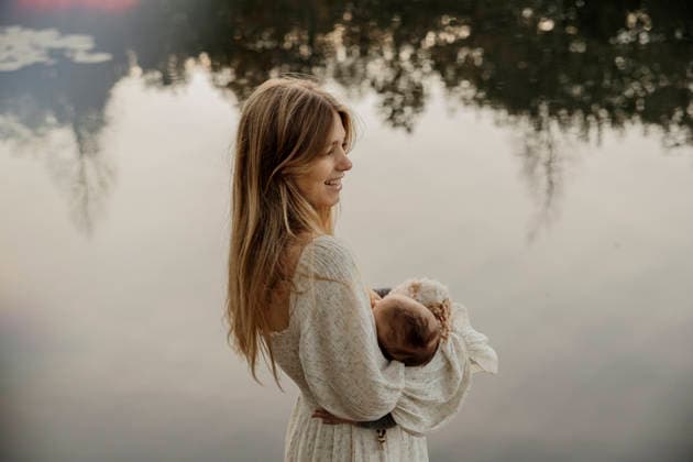 Woman in long dress holding baby by a calm reflective lake Amsterdam, North Holland, Netherlands CR_RTBZ251201D-1900959-01 ,model released, Symbolfoto