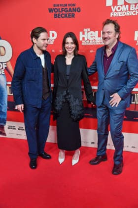 Daniel Brühl, Christiane Paul und Charly Hübner bei der Premiere von DER HELD VOM BAHNHOF FRIEDRICHSTRASSE im Delphi Filmpalast in Berlin 02.12.2025