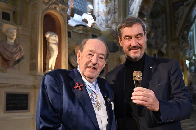 Ralph SIEGEL (Komponist) schenkt Markus SOEDER (Ministerpraesident Bayern und CSU Vorsitzender) ein Goldenes Mikrofon. Verleihung Bayerischer Maximiliansorden am 03.12.2025 im Antiquariat der Residenz in Muenchen.