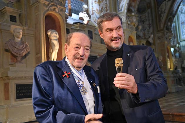 Ralph SIEGEL (Komponist) schenkt Markus SOEDER (Ministerpraesident Bayern und CSU Vorsitzender) ein goldenes Mikrofon. Verleihung Bayerischer Maximiliansorden am 03.12.2025 im Antiquariat der Residenz in Muenchen.