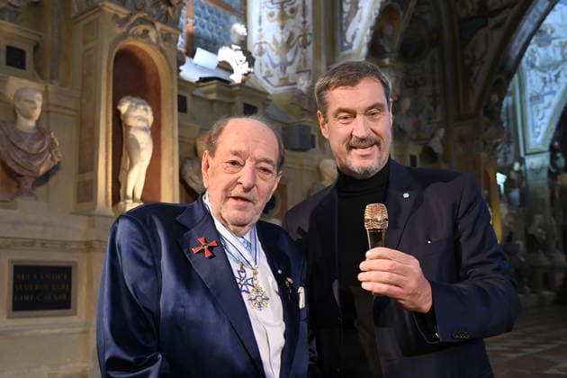Ralph SIEGEL (Komponist) schenkt Markus SOEDER (Ministerpraesident Bayern und CSU Vorsitzender) ein goldenes Mikrofon. Verleihung Bayerischer Maximiliansorden am 03.12.2025 im Antiquariat der Residenz in Muenchen.