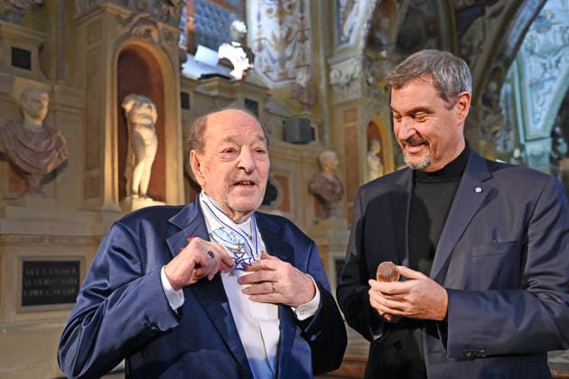 Ralph SIEGEL (Komponist) schenkt Markus SOEDER (Ministerpraesident Bayern und CSU Vorsitzender) ein goldenes Mikrofon. Verleihung Bayerischer Maximiliansorden am 03.12.2025 im Antiquariat der Residenz in Muenchen.