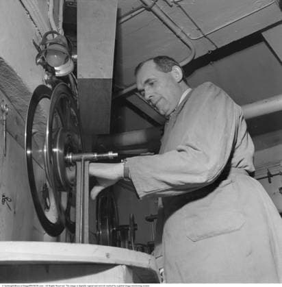 Hinter den Kulissen des Kinos. Der Projektorraum im Rita Kino in der Birger Jarlsgatan in Stockholm. Eine Filmaufwickelbank ist ein Gerät, mit dem Kinovorführer Filmrollen nach einer Vorführung manuell oder motorisiert zurückspulen. Es besteht in der Regel aus zwei Spindeln, die auf einer Bank oder einem Rahmen montiert sind, sodass der Film zur späteren Verwendung oder Inspektion wieder auf die ursprüngliche Rolle übertragen werden kann. Diese Ausrüstung war im Zeitalter der analogen Projektion unverzichtbar, um Filme für wiederholte Vorführungen vorzubereiten Behind the scenes at the movie theatre. The projector room at the Rita cinema on Birger Jarlsgatan in Stockholm. A film rewind bench is a device used by cinema projectionists to Copyright: imageBROKER Sjoberg ibljsj15798063.jpg