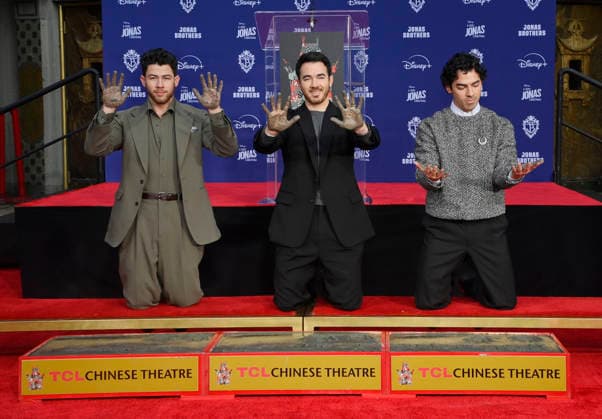 (L-R) Nick Jonas, Kevin Jonas and Joe Jonas of the Jonas Brothers participate in a hand and footprint ceremony immortalizing them in the forecourt of the TCL Chinese Theatre (formerly Grauman s) in the Hollywood section of Los Angeles on Wednesday, December 3, 2025.  LAP2025120302 JIMxRUYMEN