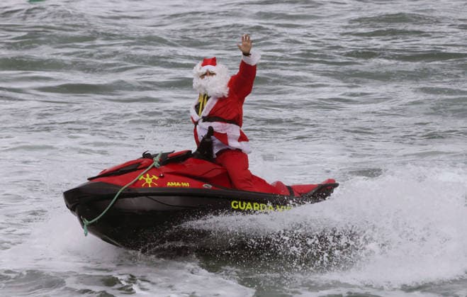 December 4, 2025, Rio De Janeiro, Rio De Janeiro, Brazil: A firefighter dressed as Santa Claus traded his sleigh for a jetski, arriving at Copacabana Beach in Rio de Janeiro to surprise children battling cancer, disabilities, and rare diseases during the annual Grains of Gratitude Christmas event. The full-day program treats young patients to beach games, ocean activities, and special demonstrations before SantaÃ¢â‚¬â ¢s splashy arrival and gift distribution. Rio De Janeiro Brazil - ZUMAk251 20251204_znp_k251_001 Copyright: xBobxKarpx