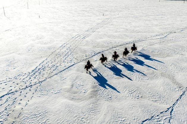 (251205) -- BEIJING, Dec. 5, 2025 -- An aerial drone photo taken on Dec. 2, 2025 shows policemen of the Gyrfalcon mounted police team patrolling on snow-covered Chenbarhu Banner Grassland in Hulun Buir, north China s Inner Mongolia Autonomous Region. ) XINHUA PHOTOS OF THE DAY MaxJinrui 