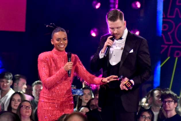 ABBbielefeld: Aminata Belli Moderatorin mit Finch, Nils Wehowsky mit Krone Preistraeger auf der Show Behne bei der Verleihung des WDR Musikpreis 1 Live Krone im Lokschuppen Bielefeld am 04.12.2025 NRW Deutschland