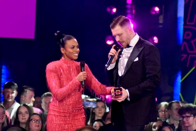 ABBbielefeld: Aminata Belli Moderatorin mit Finch, Nils Wehowsky mit Krone Preistraeger auf der Show Behne bei der Verleihung des WDR Musikpreis 1 Live Krone im Lokschuppen Bielefeld am 04.12.2025 NRW Deutschland