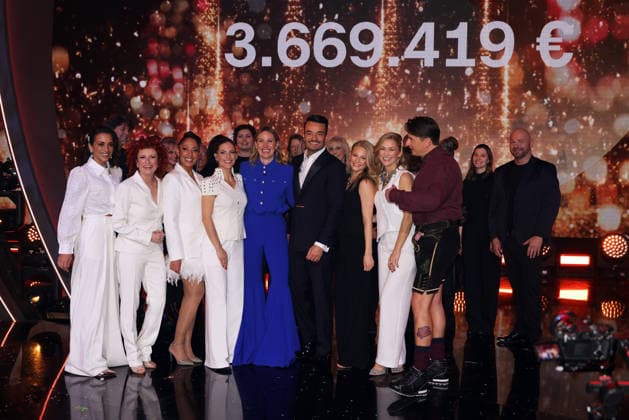 Die große Weihnachtsshow 2025 Moderator Giovanni Zarrella und Mitwirkende mit der gespendeten Summe auf der Leinwand. V.li. Nadja Benaissa, Lucy Diakovska, Jessica Wahls und Sandy Mölling von den No Angels, Evelyn Weigert, Giovanni Zarrella, Julia Lindholm, Linda Hesse, Andreas Gabalier). Die große Weihnachtsshow präsentiert von Giovanni Zarrella. ZDF-Live Sendung vom 04.12.2025 in der Baden-Arena Offenburg. Offenburg, Baden-Württemberg, Deutschland.