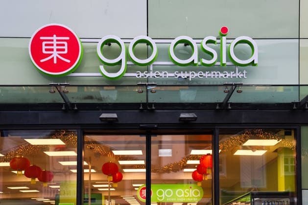 Kiel, Germany - 01. December 2025: Go Asia Asien Supermarkt-Front in Kiel, Germany mit gebrandetem Schild, Laternen und Eingang, die Kunden zu asiatischen Lebensmitteln und Importwaren einlädt *** Kiel, Germany 01 December 2025 Go Asia Asia Supermarket Front in Kiel, Germany with branded Shield, Lanterns and Entrance, the Customers to Asian Food and Imported goods invites 1127162667