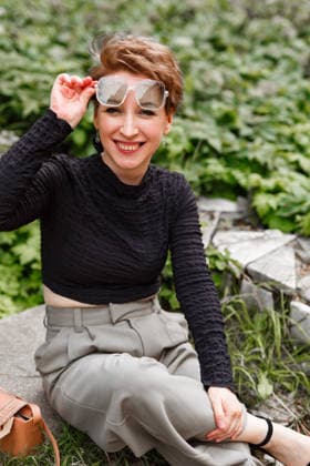 Middle aged woman enjoying a sunny day in nature A happy middle-aged woman sits outdoors with greenery, adjusting her sunglasses and smiling warmly, capturing a joyful moment surrounded by nature s beauty. Model Released Aveamig_ID32434_1105265_009 Copyright: xx RECORD DATE NOT STATED