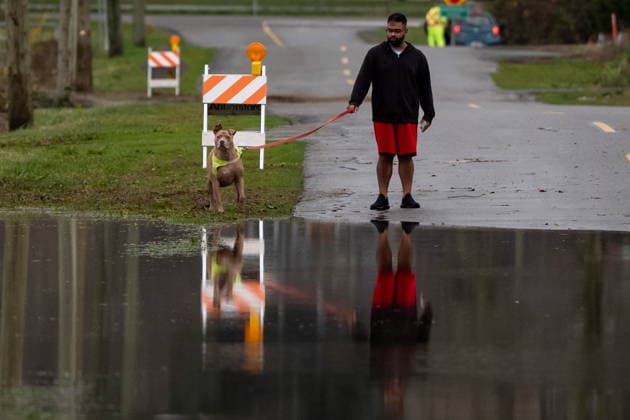 December 11, 2025, Vancouver, Bc, CANADA: A man walks his dog by a flooded street in Abbotsford B.C., on Thursday, December 11, 2025. Vancouver CANADA  - ZUMAc35_ 20251211_zaf_c35_095 Copyright: xEthanxCairnsx