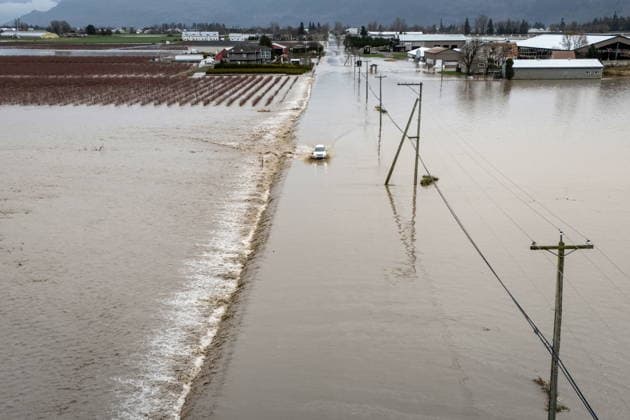 December 11, 2025, Vancouver, Bc, CANADA: A car crosses a flooded street in Abbotsford B.C., on Thursday, December 11, 2025. Vancouver CANADA  - ZUMAc35_ 20251211_zaf_c35_147 Copyright: xEthanxCairnsx