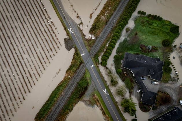 December 12, 2025, Abbotsford, Bc, CANADA: Floodwaters surround an intersection of road and train tracks in Abbotsford, B.C., on Friday, Dec. 12, 2025. Abbotsford CANADA  - ZUMAc35_ 20251212_zaf_c35_053 Copyright: xEthanxCairnsx