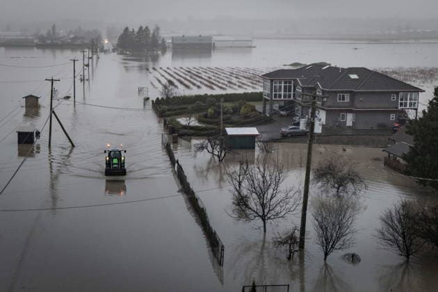 December 12, 2025, Abbotsford, Bc, CANADA: A tractor drives through floodwaters in Abbotsford, B.C., on Friday, Dec. 12, 2025. Abbotsford CANADA  - ZUMAc35_ 20251212_zaf_c35_055 Copyright: xEthanxCairnsx
