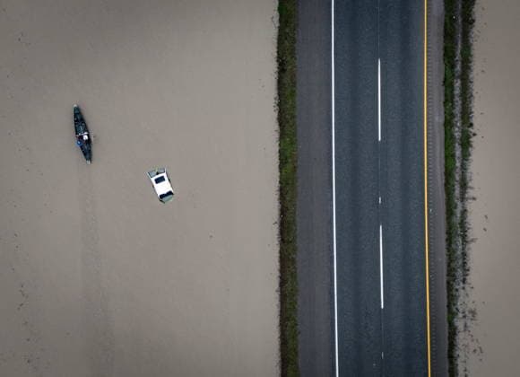 News Bilder des Tages December 12, 2025, Abbotsford, Bc, CANADA: A man paddles past a sunken vehicle along Highway 1 in Abbotsford, B.C., on Friday, Dec. 12, 2025. Abbotsford CANADA  - ZUMAc35_ 20251212_zaf_c35_058 Copyright: xEthanxCairnsx